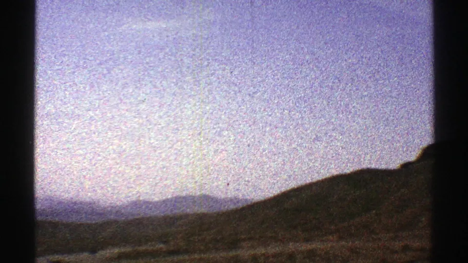 Arizona desert hillside and far ridgelines filmed on 8mm from a moving vehicle in 1969.