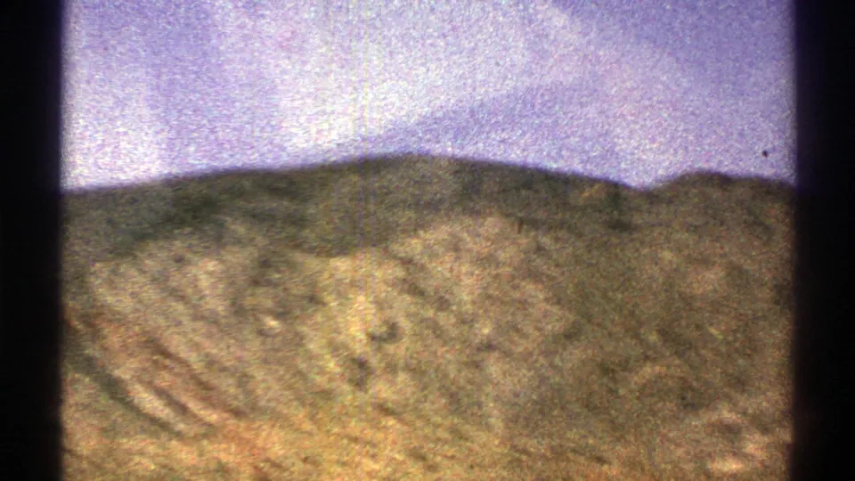 Rugged Arizona hills and brush seen in grainy 1969 8mm footage with strong color shift.