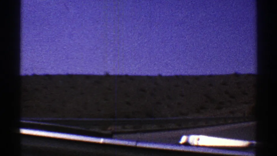 Low 8mm road-trip view from inside a vehicle toward an Arizona desert horizon under a blue-purple sky.