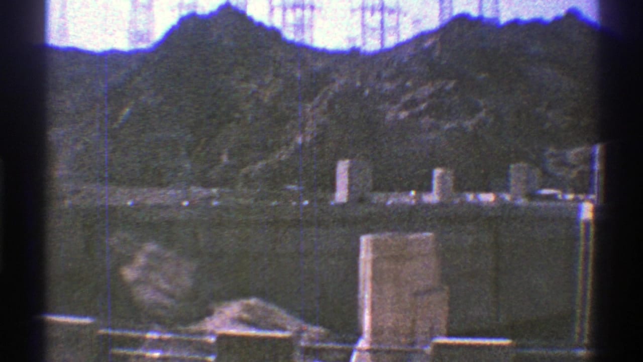 1969 8mm view of Hoover Dam structures, reservoir water, and rugged canyon slopes near the Colorado River.