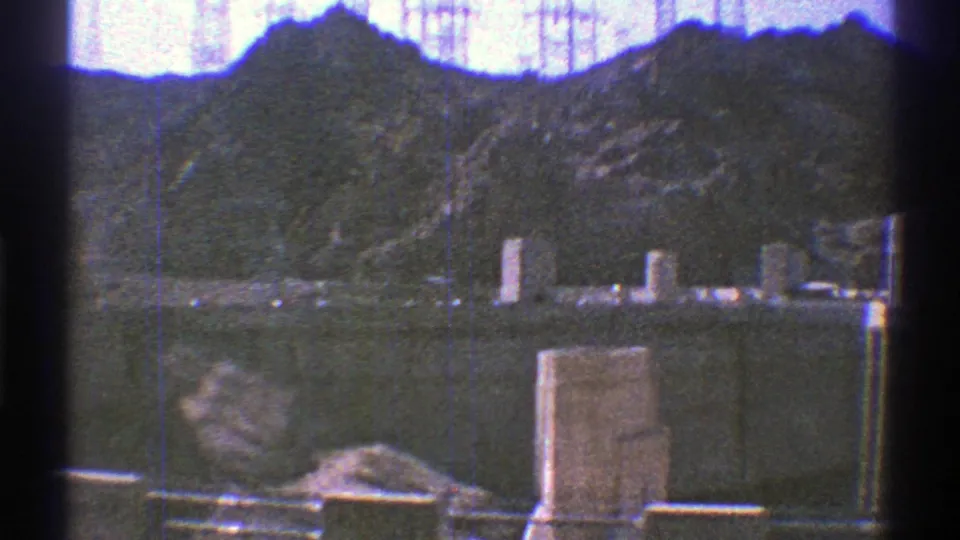 1969 8mm view of Hoover Dam structures, reservoir water, and rugged canyon slopes near the Colorado River.
