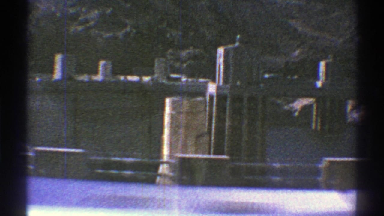 Concrete dam edge, intake towers, water, and canyon wall in bright sun.