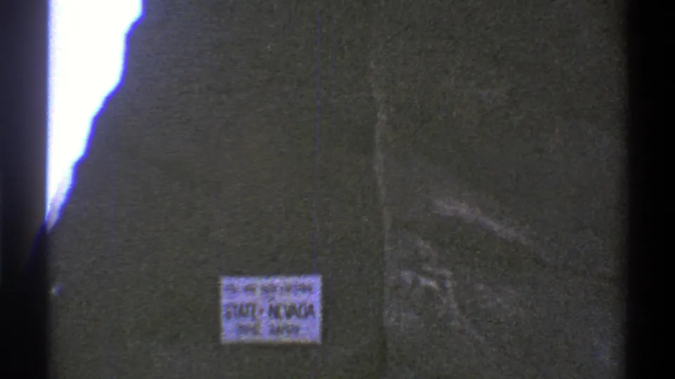 1969 8mm frame showing a Nevada state-entry safety sign filmed close-up during a Southwest road trip.