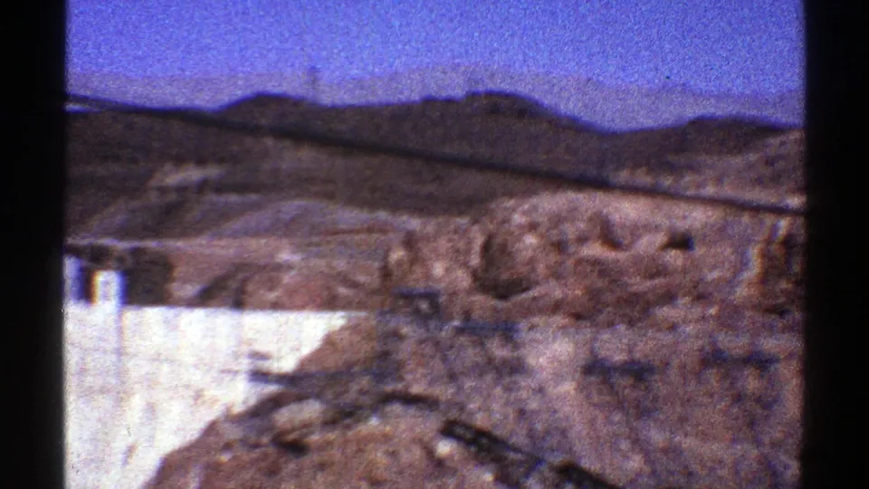 A 1969 Arizona view shows rocky desert terrain in front of a partial Hoover Dam structure and distant hills.