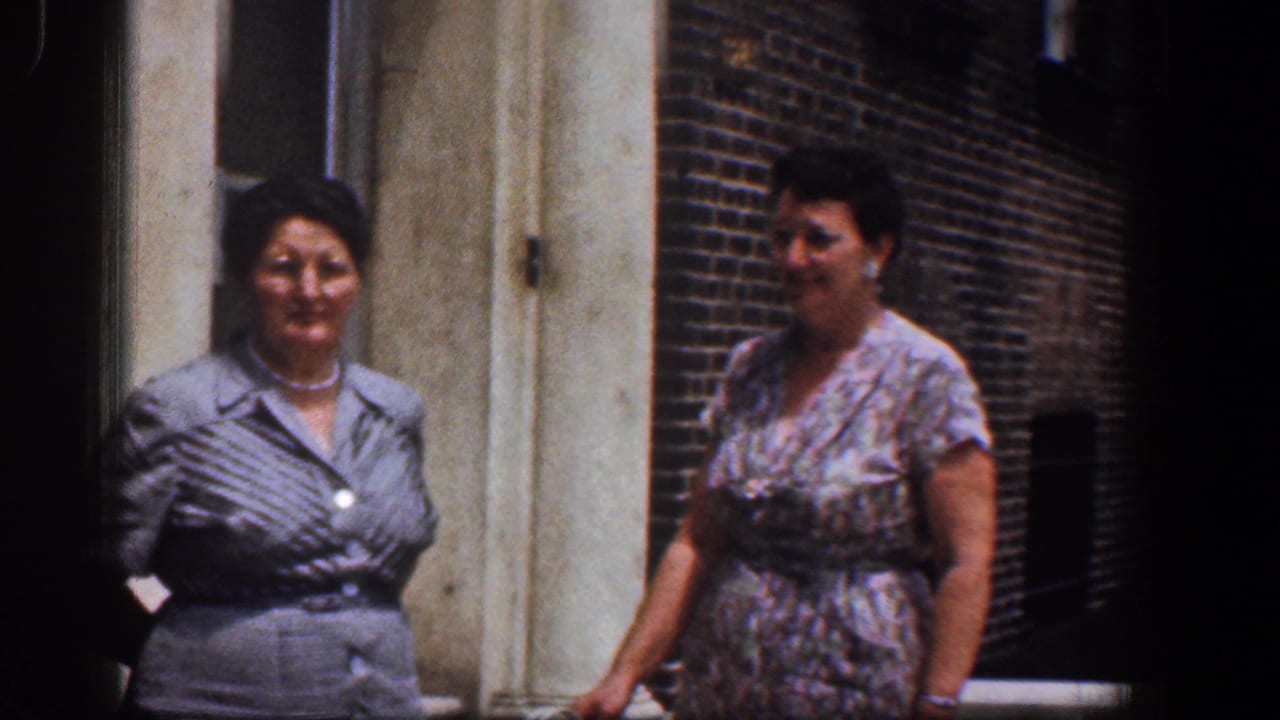 Two adult women in dresses stand outside a brick building in Baltimore, supported by the 1961 clip metadata.
