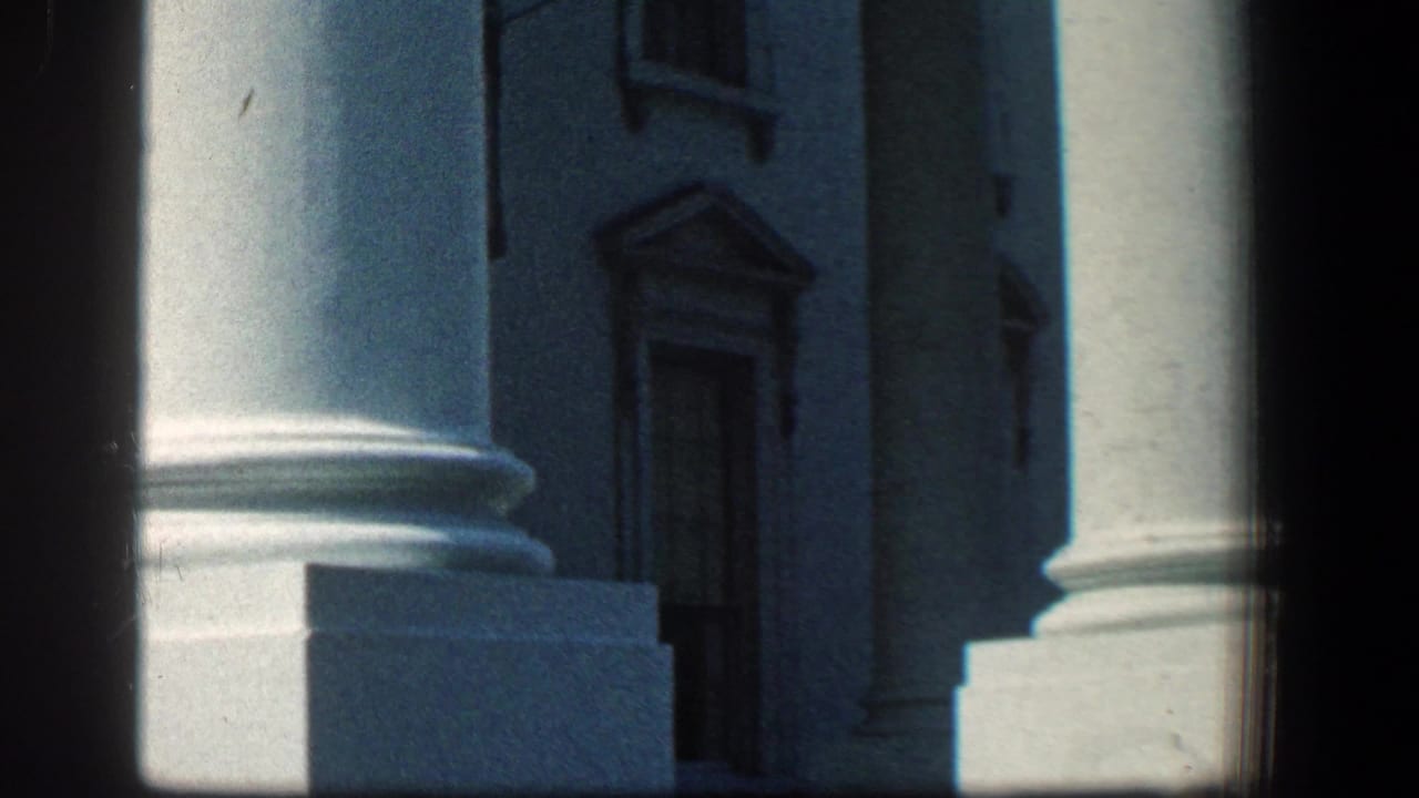 Large white columns and shadowed stone entrance on a historic building.
