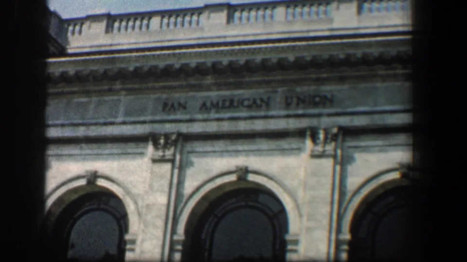 Close 1961 home-movie view of the Pan American Union facade, with lettering, arched windows and stone architectural detail.