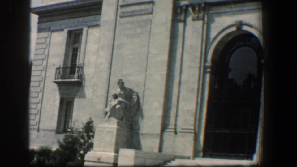 1961 Baltimore frame showing a statue on a pedestal beside an arched doorway on the Pan American Union building exterior.