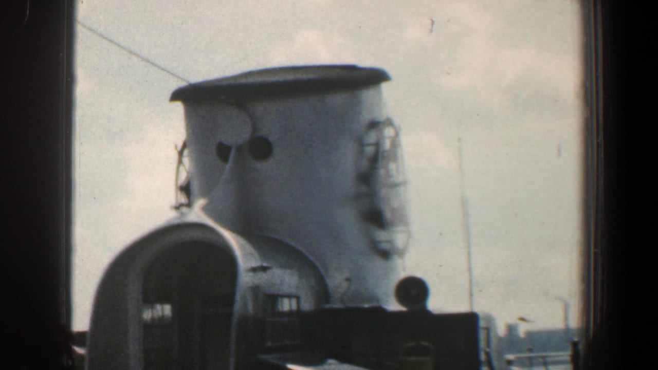 Close view of a ship smokestack and deck equipment against the sky.