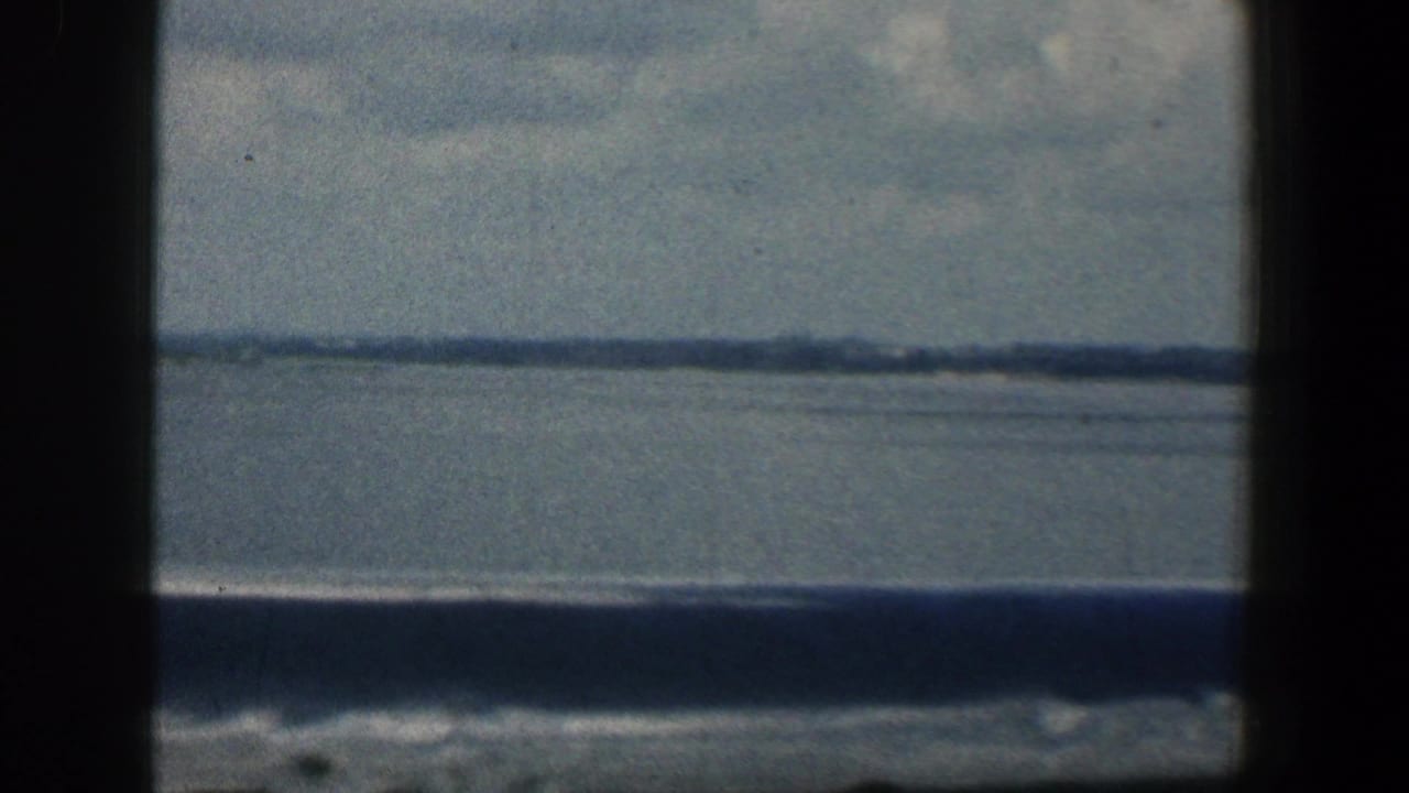 Wide water view with low shoreline and dark foreground framing.