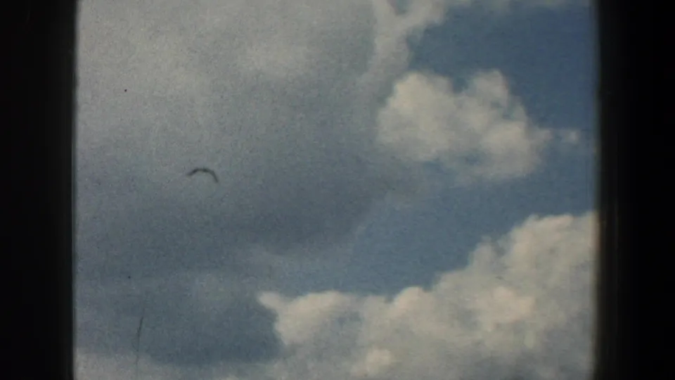 Clouds and blue sky in faded 8mm color, likely from the same Baltimore harbor home-movie sequence.