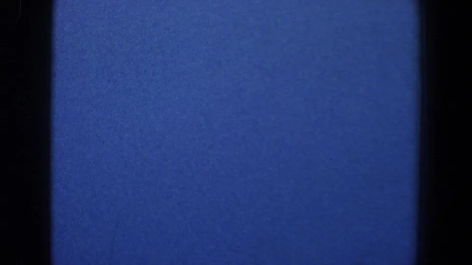 A very dark 1961 8mm frame from Baltimore with blue color cast, black gate edges, and no clearly identifiable subject.