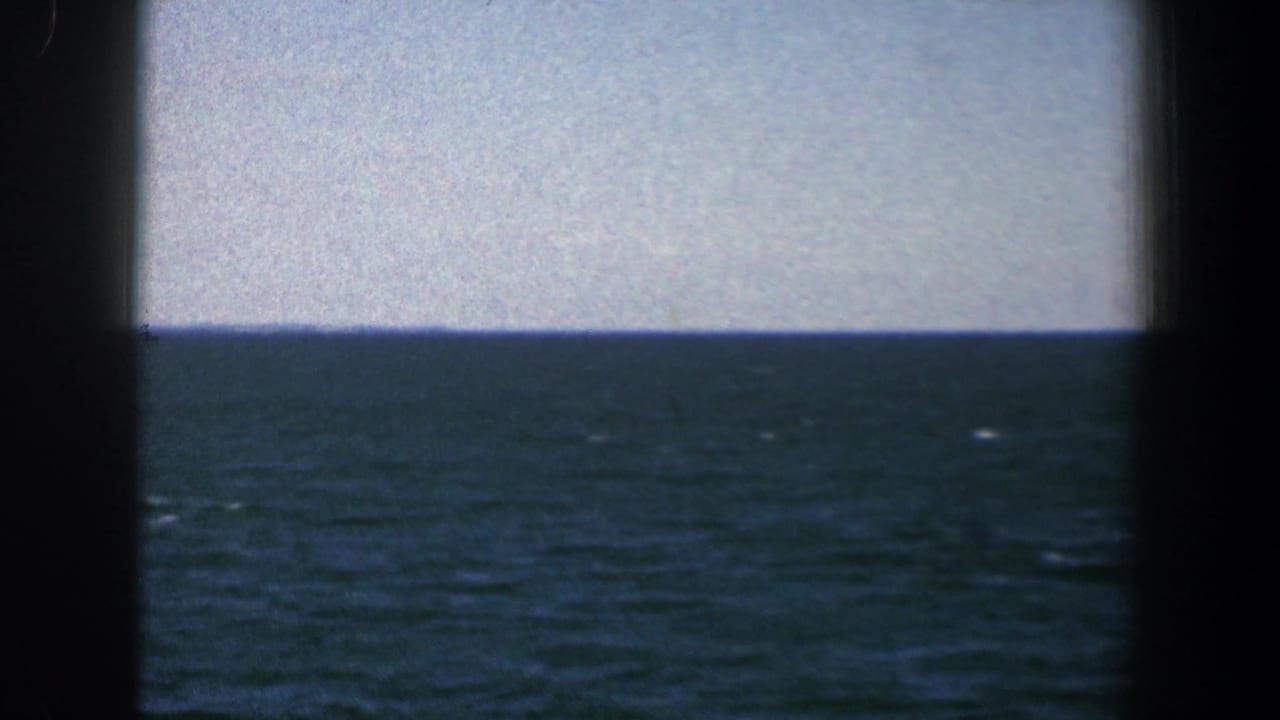 Open water and pale sky divided by a dark central window frame.