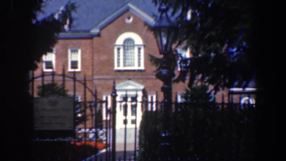 A closer 1961 Baltimore view shows the white doorway and arched window of a brick building behind ironwork.