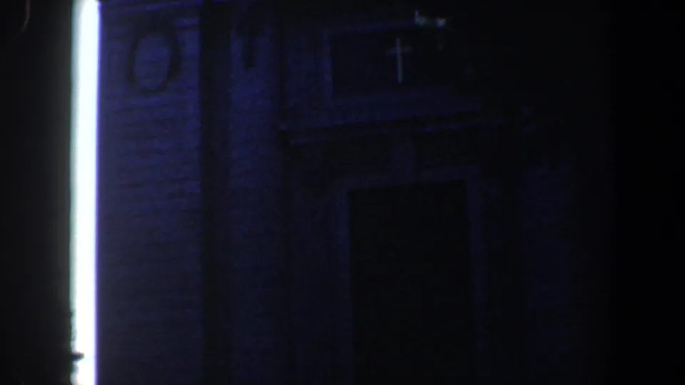 1961 Baltimore church exterior showing a cross above the entrance, brickwork, and strong vertical light in a dark 8mm frame.