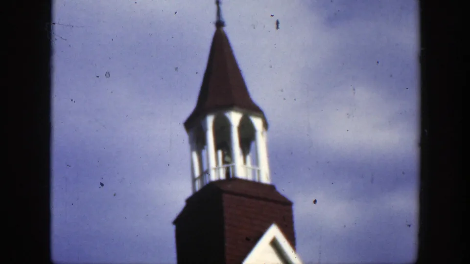 1950 Montreal frame with the church bell tower shifted to the right, showing the cupola, roof, and pale sky.