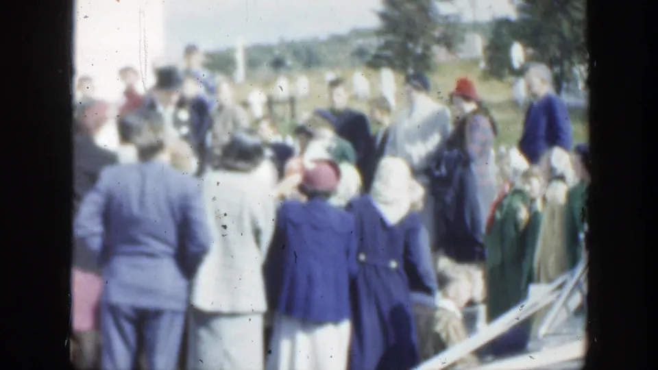1950 Montreal wedding guests stand near a parked car, with flowers and formal clothing visible in the crowd.