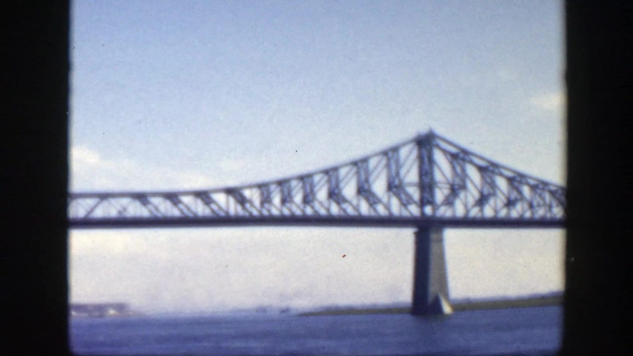 Jacques-Cartier Bridge truss and pier seen from the water in a soft 1950 Montreal 8mm frame.