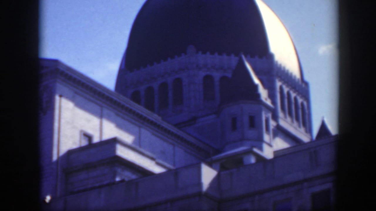Large domed church roof seen against blue sky from a close elevated angle.