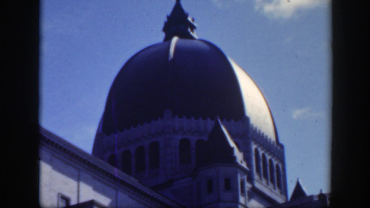 Domed church roof with a small cross-topped feature against the sky.