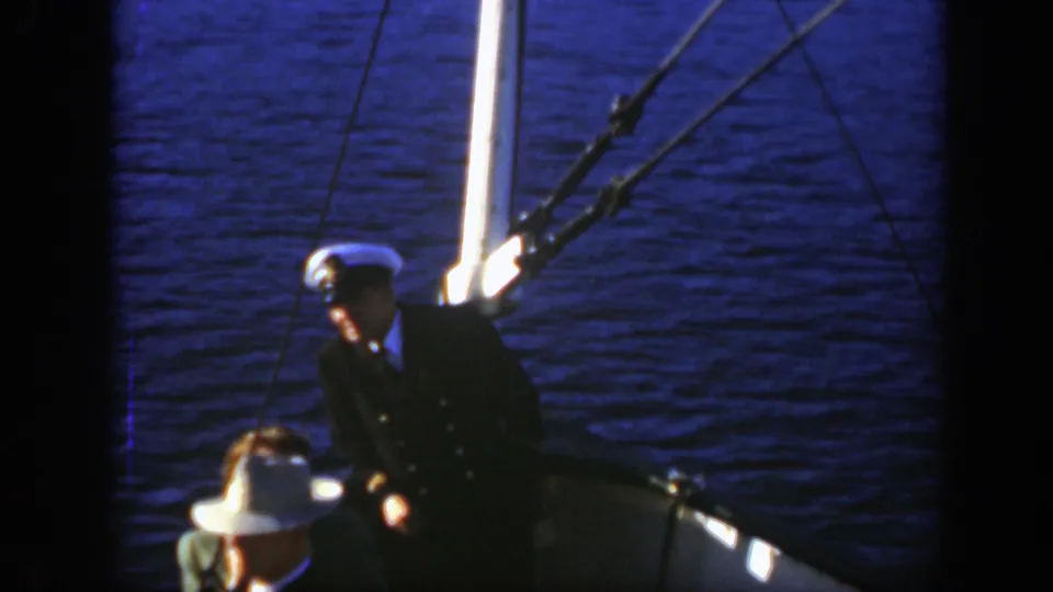 A 1950 boat-deck frame shows a uniformed man near rigging with another person partly visible in the foreground.