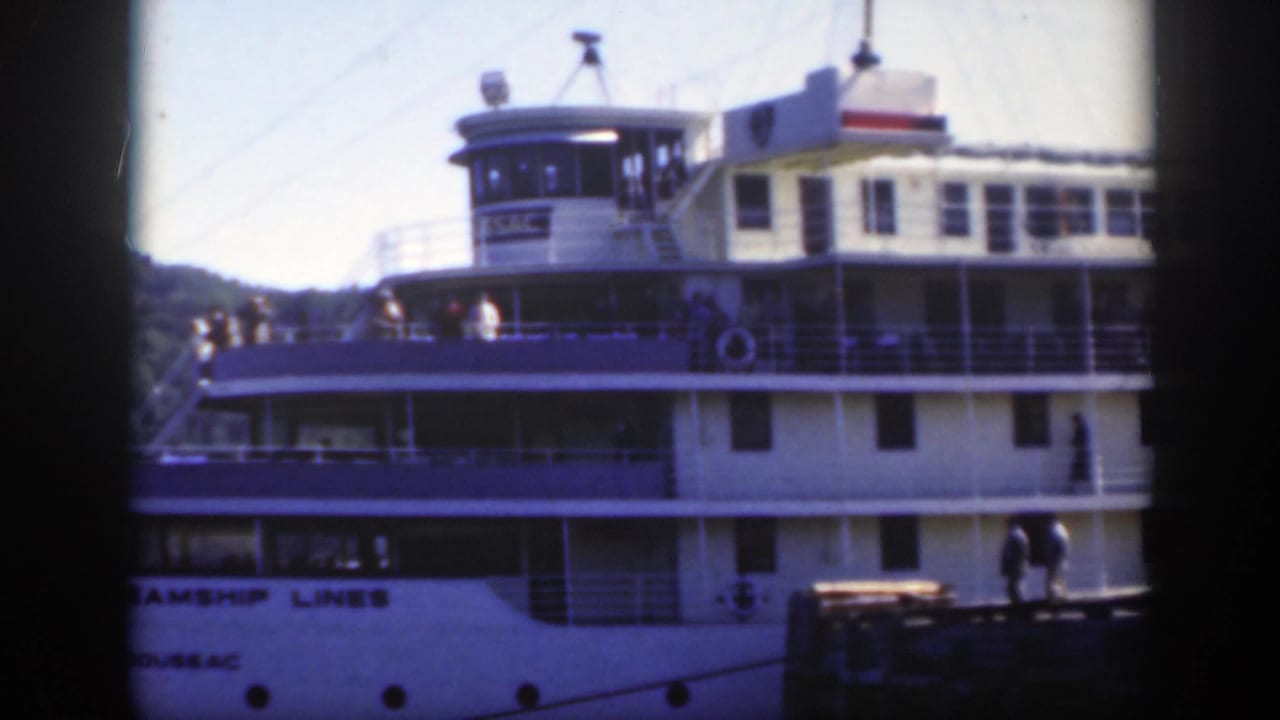 The white Canada Steamship Lines vessel fills the frame, with passengers on the open decks in Montreal.