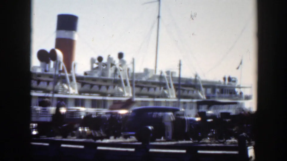 1950 Montreal harbor view showing spectators and parked cars near a large passenger ship with a striped funnel.