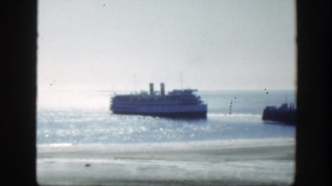 1950 8mm view near Montreal, with a passenger ferry crossing sunlit water behind a dark window frame.
