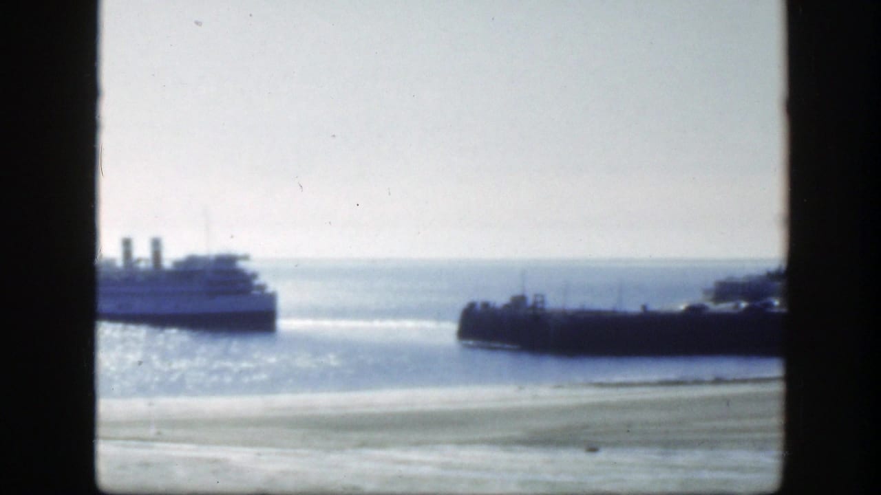 Passenger boat on bright water seen through a dark window frame.