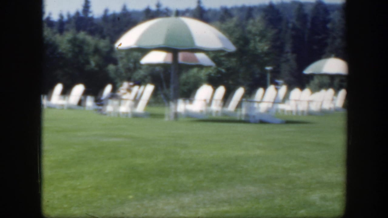 Lawn seating and striped umbrellas seen across a grassy resort area.
