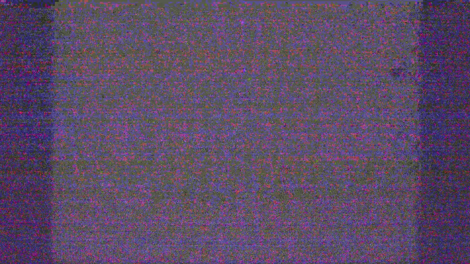 End frame from the 8mm scan showing heavy noise and darkness with no clear people or building detail visible.