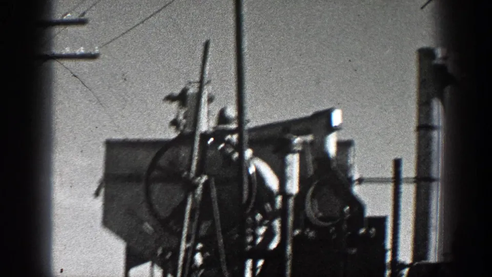 Rear portion of the 1936 California scene showing towed farm machinery and trailer hardware beside roadside utility poles.