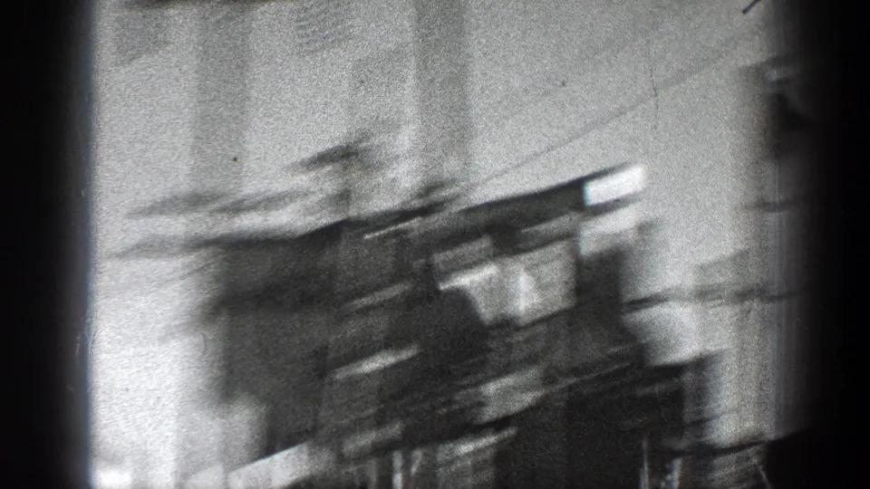 Motion-blurred 1936 California frame with utility hardware, wires, and a dark vertical film or foreground obstruction.