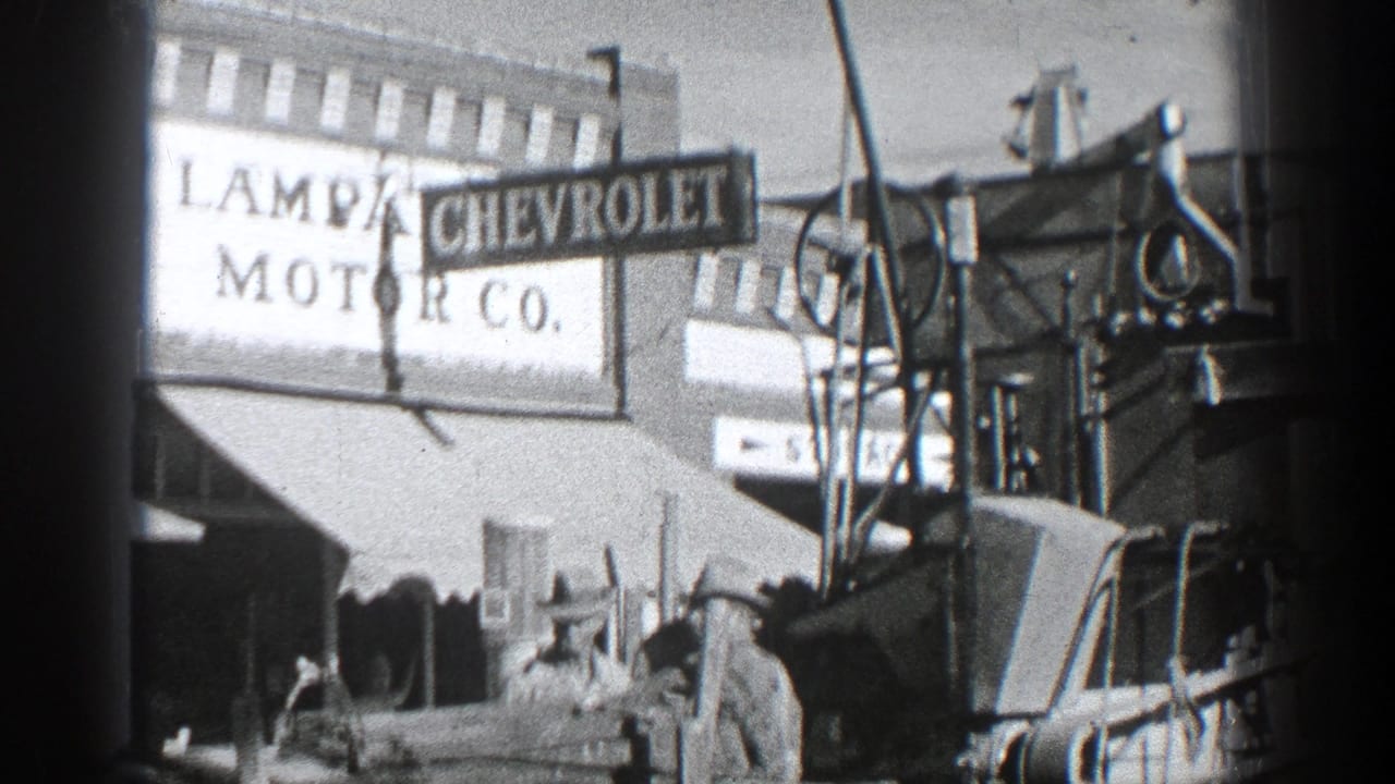 Chevrolet sign outside a motor company storefront with vehicles at the curb.