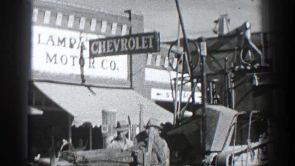 Chevrolet Motor Co. signage appears above a California commercial street scene with awnings and early automobiles in view.
