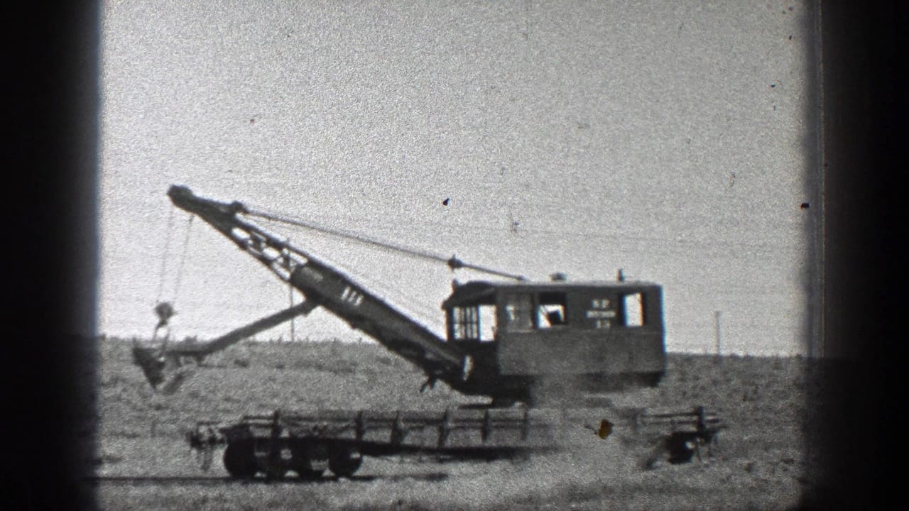 1936 California home-movie frame showing a tracked heavy field machine with an extended boom on open rural ground.