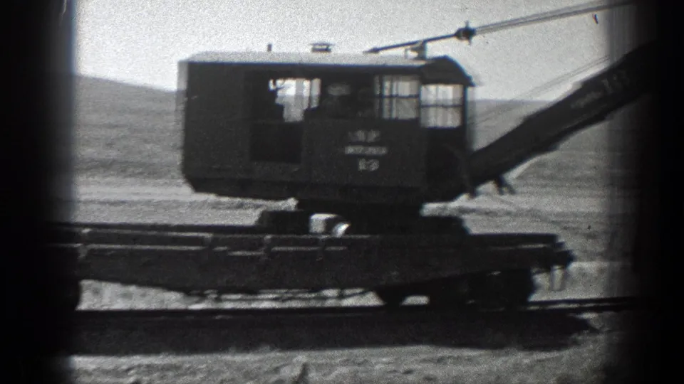 1936 California 8mm frame showing an N.P. Pitcher crane on a track or rail-like base at an open construction site.