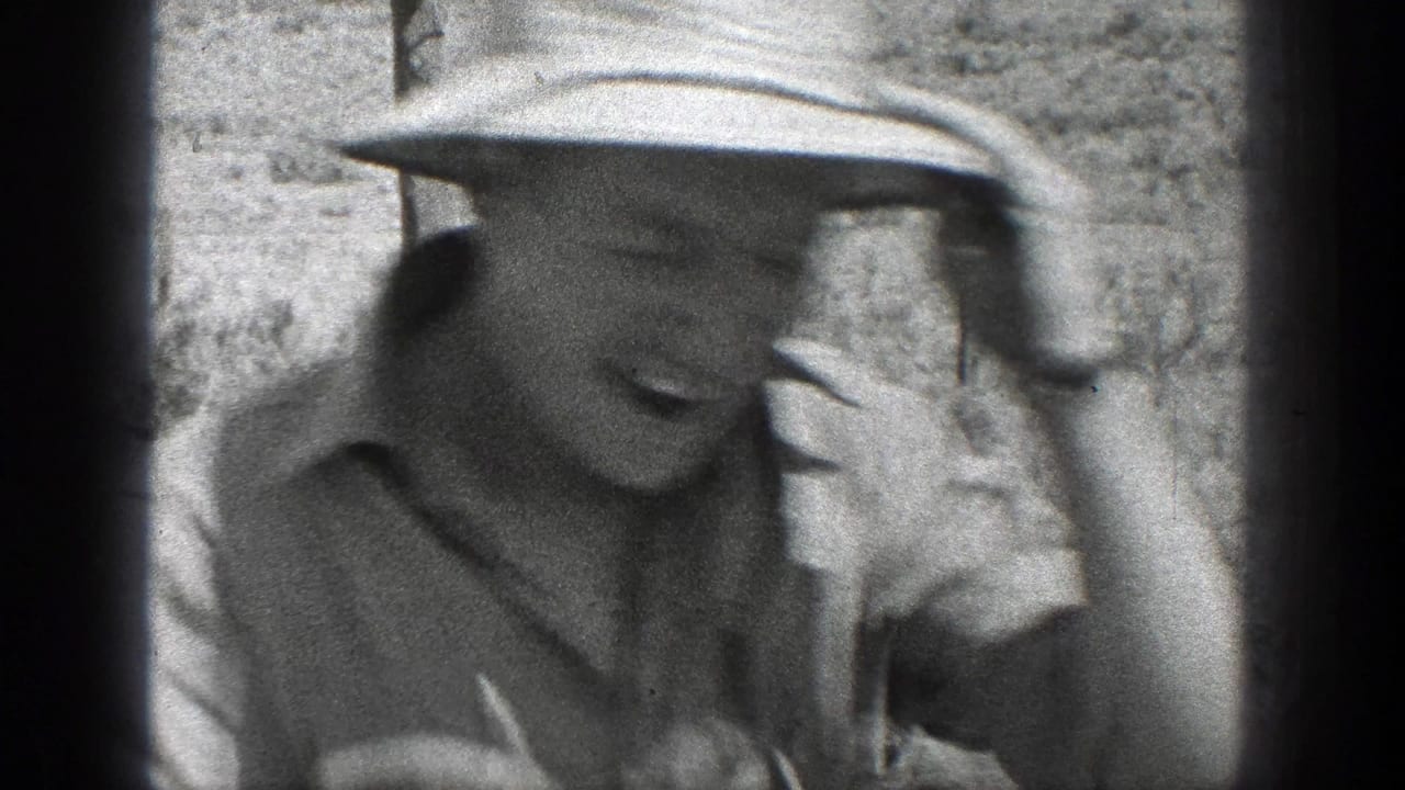Smiling man in a light hat close to the camera with dark film gate edges.