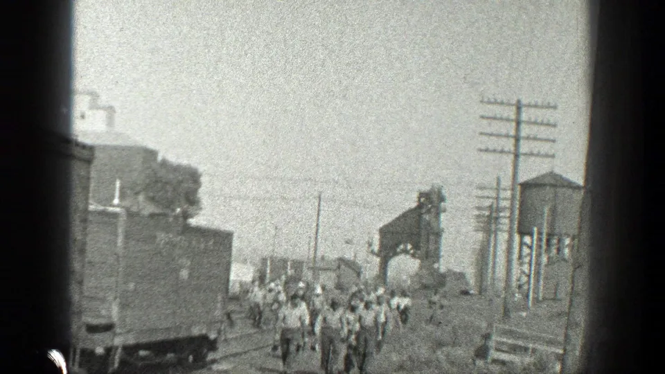 Railroad workers appear in a 1936 California rail setting, with tracks, freight equipment, poles, and a water tower visible.