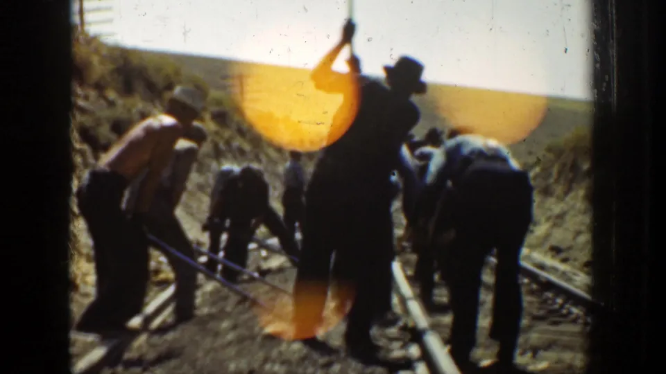 Color 8mm frame from 1936 California showing men in hats and work clothes repairing or maintaining railroad track.