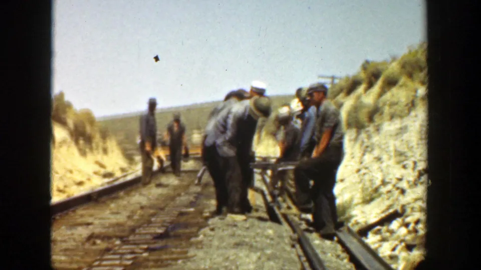 Workers in caps and work clothes align equipment on a California railroad track in 1936 home-movie footage.