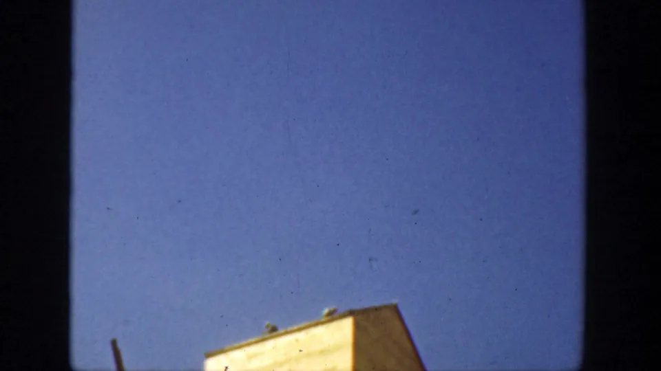 1936 California 8mm frame showing the lower edge of the elevator structure cropped against a wide blue sky.