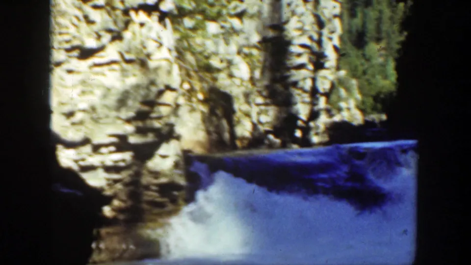 A rocky waterfall and pale stone wall dominate the 1936 California home-movie frame, with water spilling into shadow.
