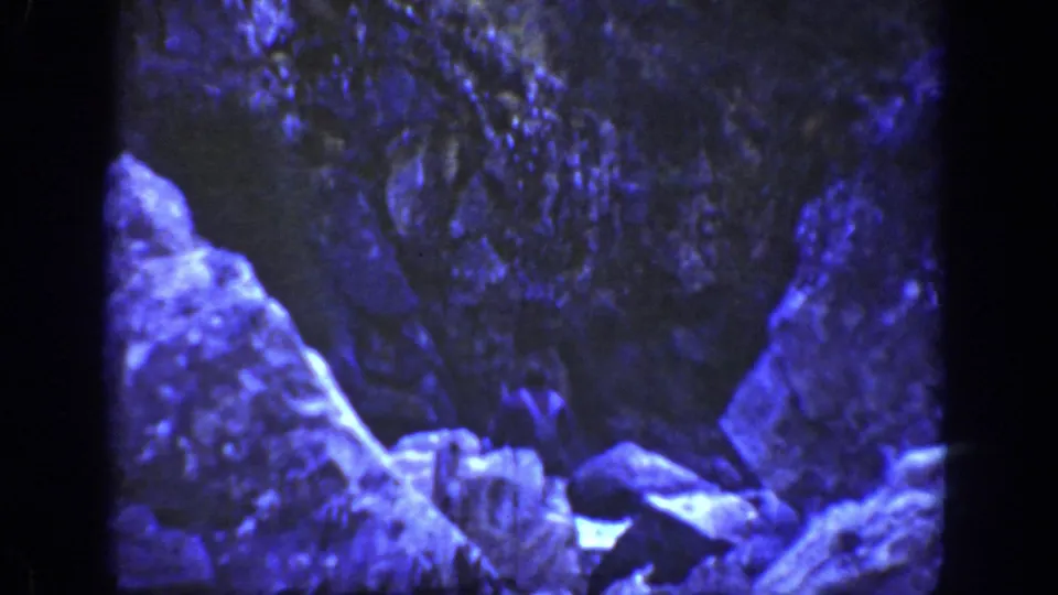 A darker, blue-shifted frame shows rocks and water below the falls, with boulders filling the foreground and no person visible.