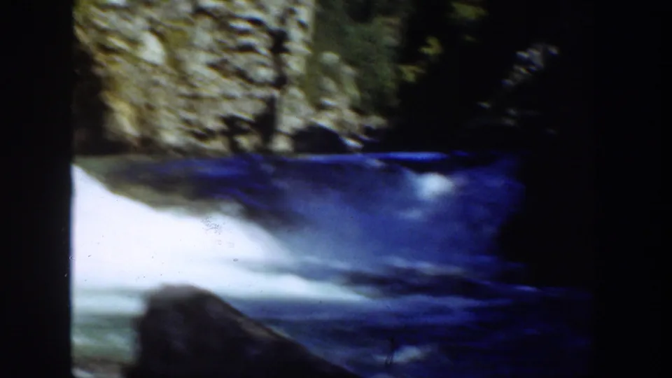 1936 California 8mm frame showing fast-moving river water passing through a rocky canyon in deep shade and sun.