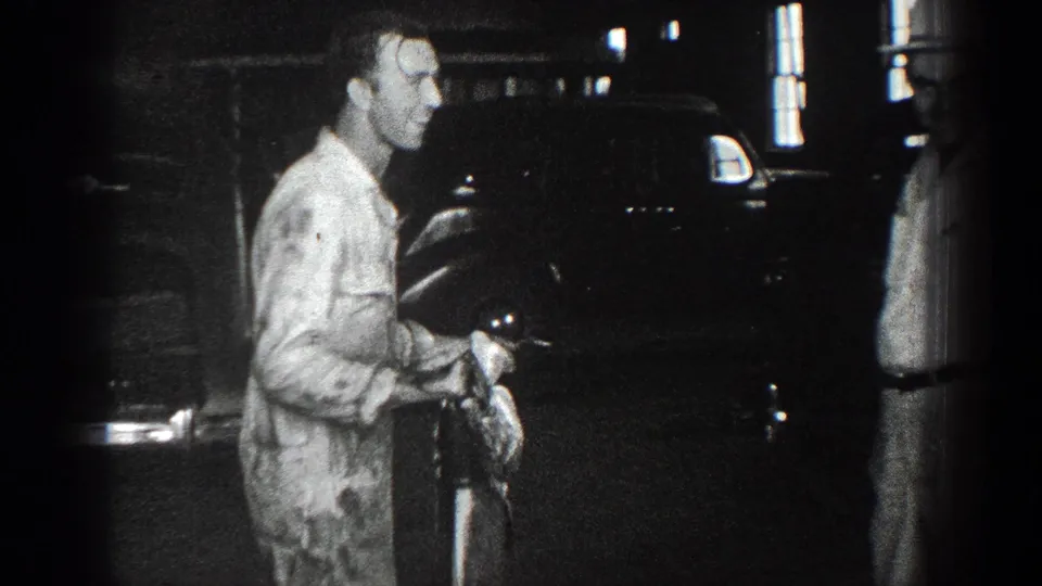 Final 1936 California frame shows a man holding the fish near a dark parked automobile, with another figure partly visible.