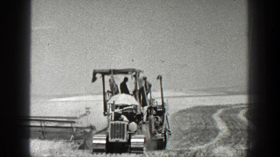 The tractor appears closer in the 1936 California farming scene, with the operator visible beneath the canopy-like frame.
