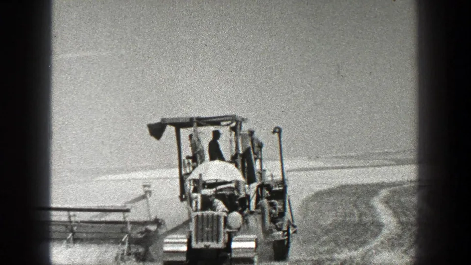 A closer 8mm frame shows the tractor and operator continuing field work in rural California in 1936.