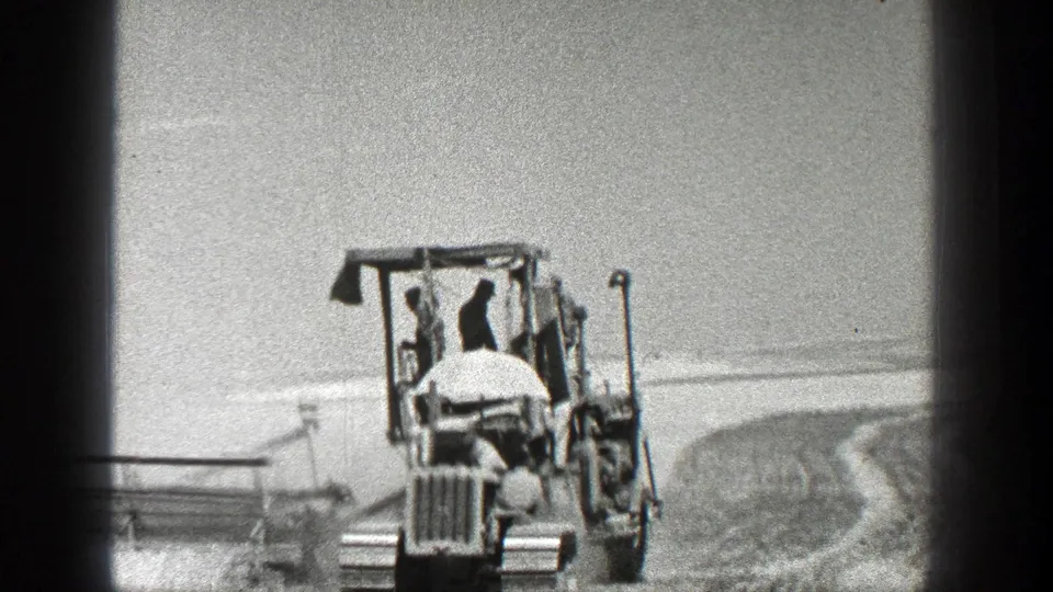 The final frame keeps the tractor centered as the operator drives through the bright California field landscape.
