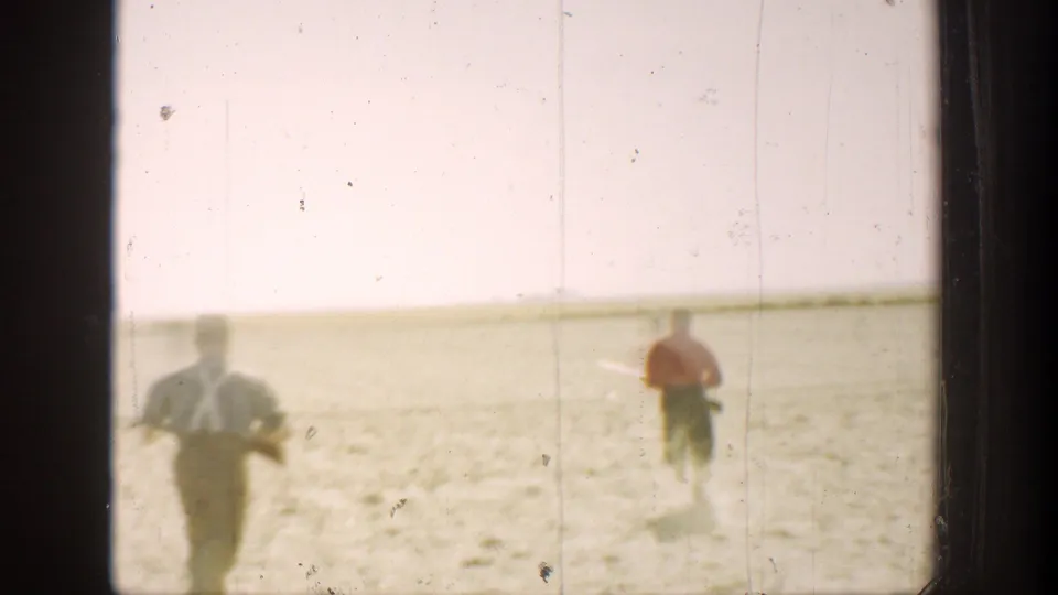 In 1936 California home-movie footage, two hunters run across sunlit arid ground under a pale sky.